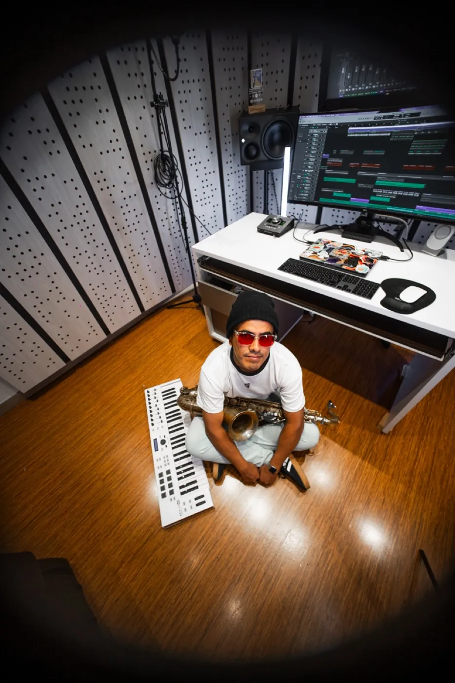 Richard en el piso del estudio con su saxofón y un teclado