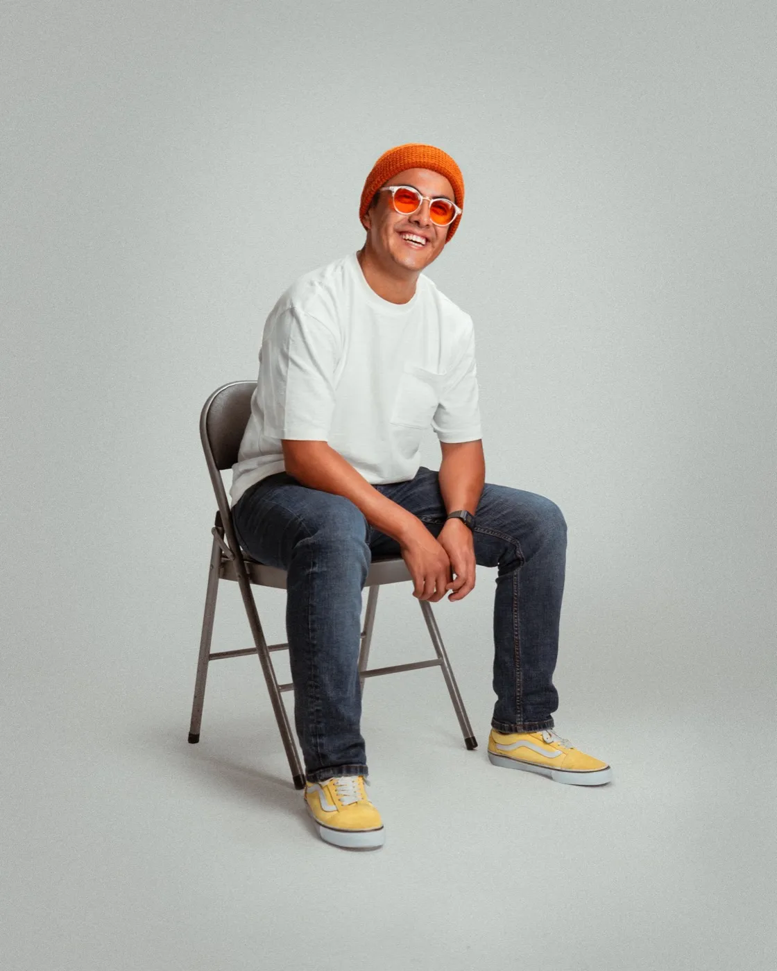 Richard sentado en una silla plegable, sonriendo