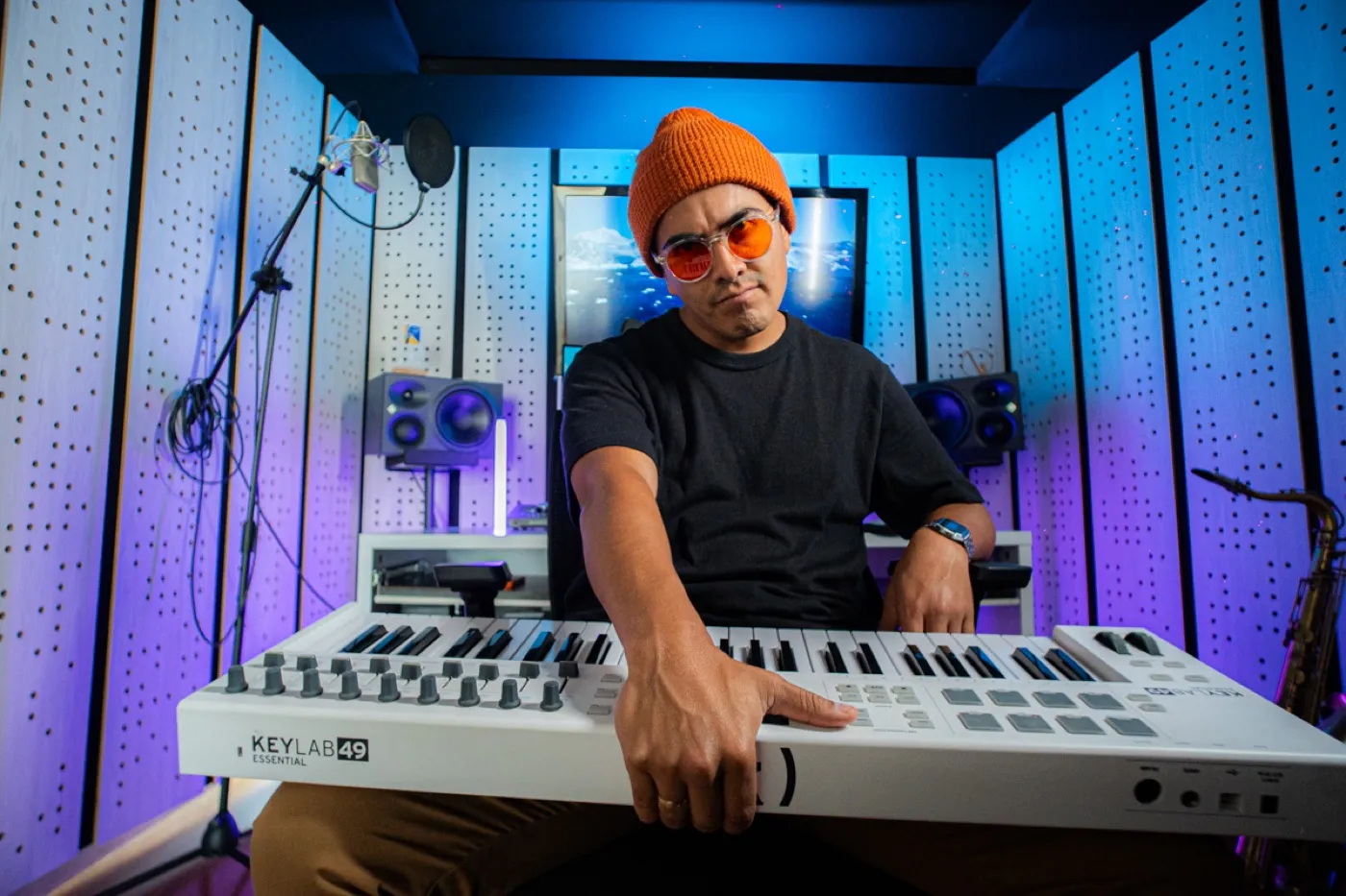 Primer plano de Richard con teclado MIDI y luz neón azul